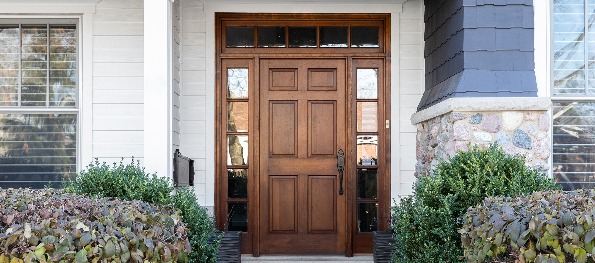 Wood entry door with sidelights and blue exterior siding